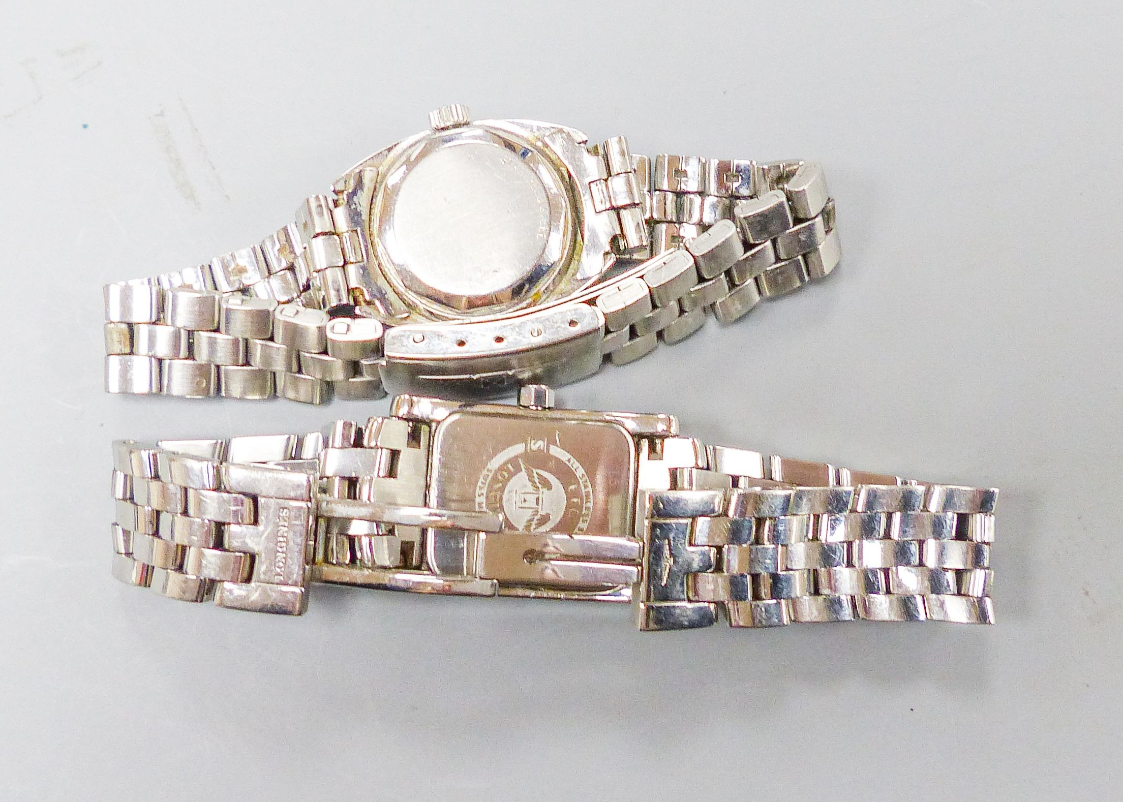 Two lady's stainless steel Longines wrist watches, one automatic and one with diamond set rectangular bezel.